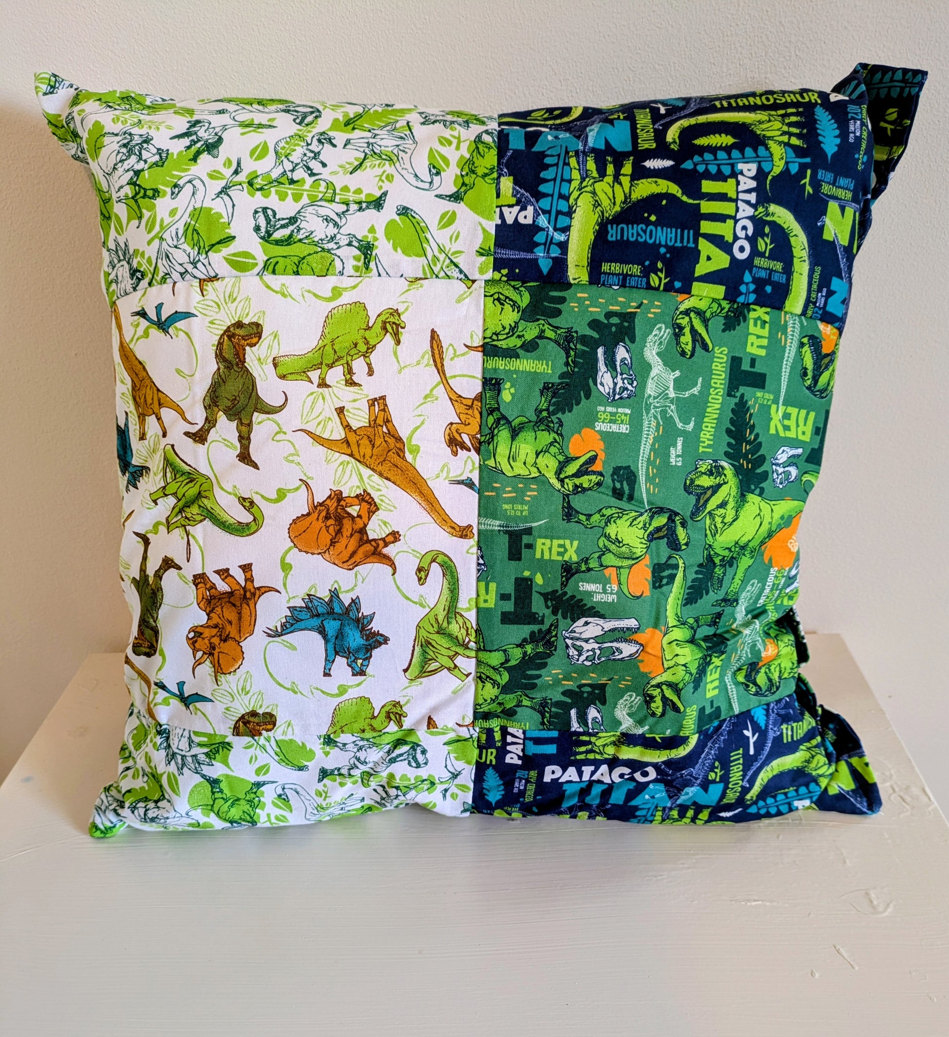 Colorful dinosaur patchwork cushion by Harrie's Crafts, showcasing a soft fabric cushion with vibrant dinosaur patterns.