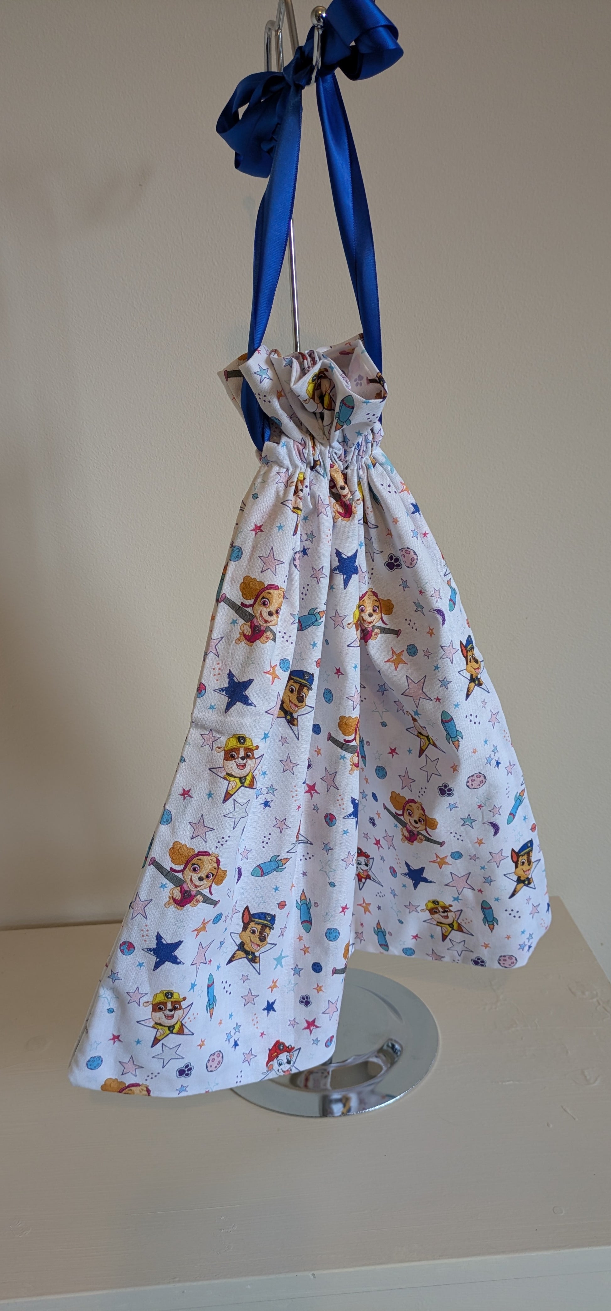Paw Patrol drawstring bag by Harrie's Crafts featuring colorful cartoon characters on a blue fabric background.