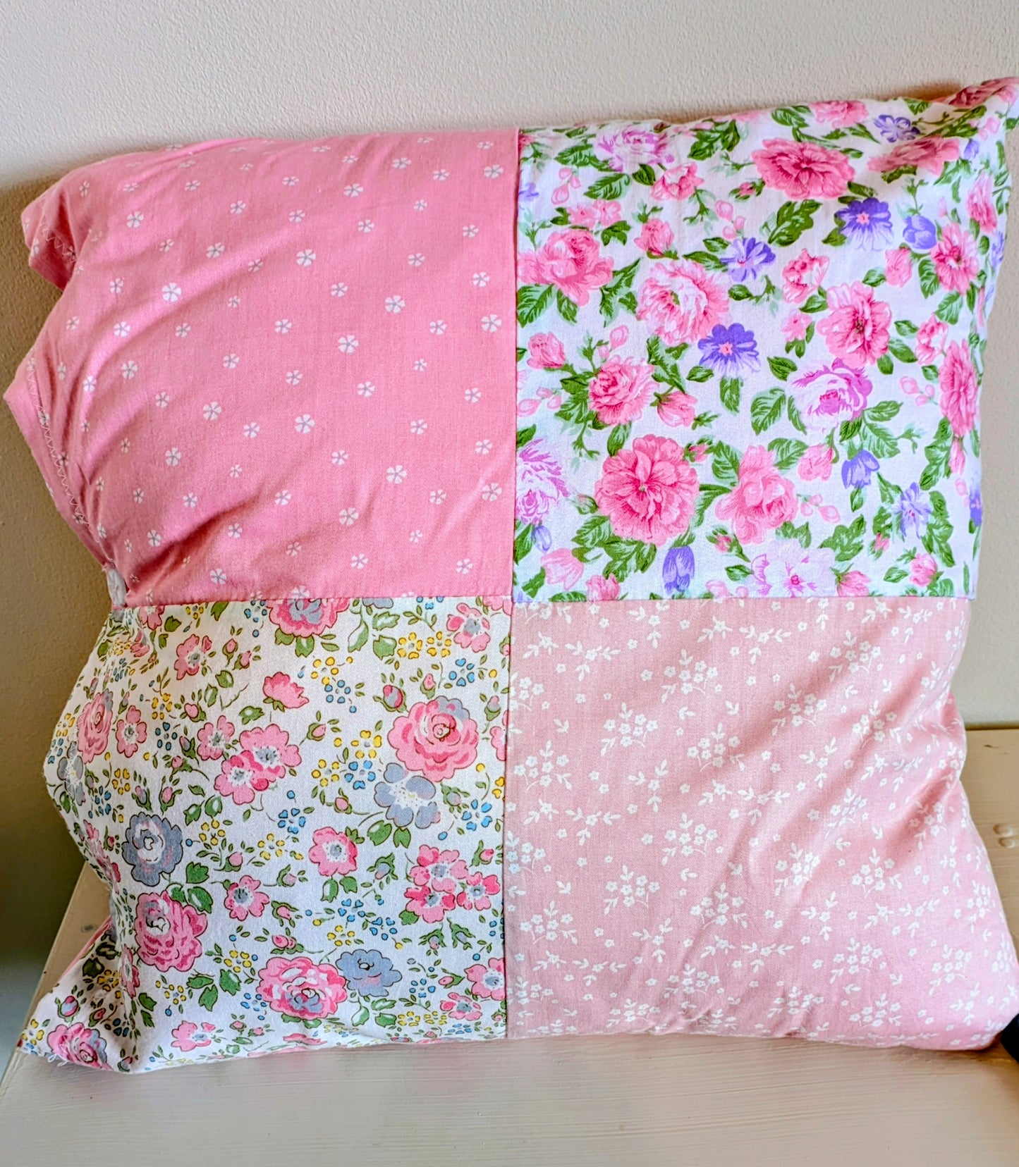 Pink flower patchwork cushion by Harrie's Crafts featuring vibrant floral fabric and soft, cozy texture.