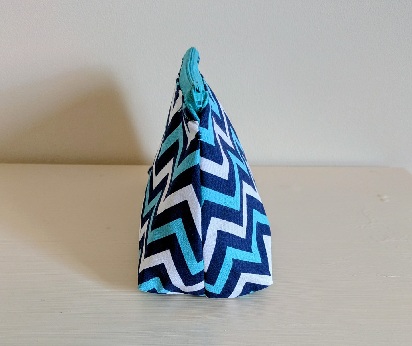 Blue and white zigzag waterproof wash bag by Harrie's Crafts, with a compact design and durable fabric for travel use.