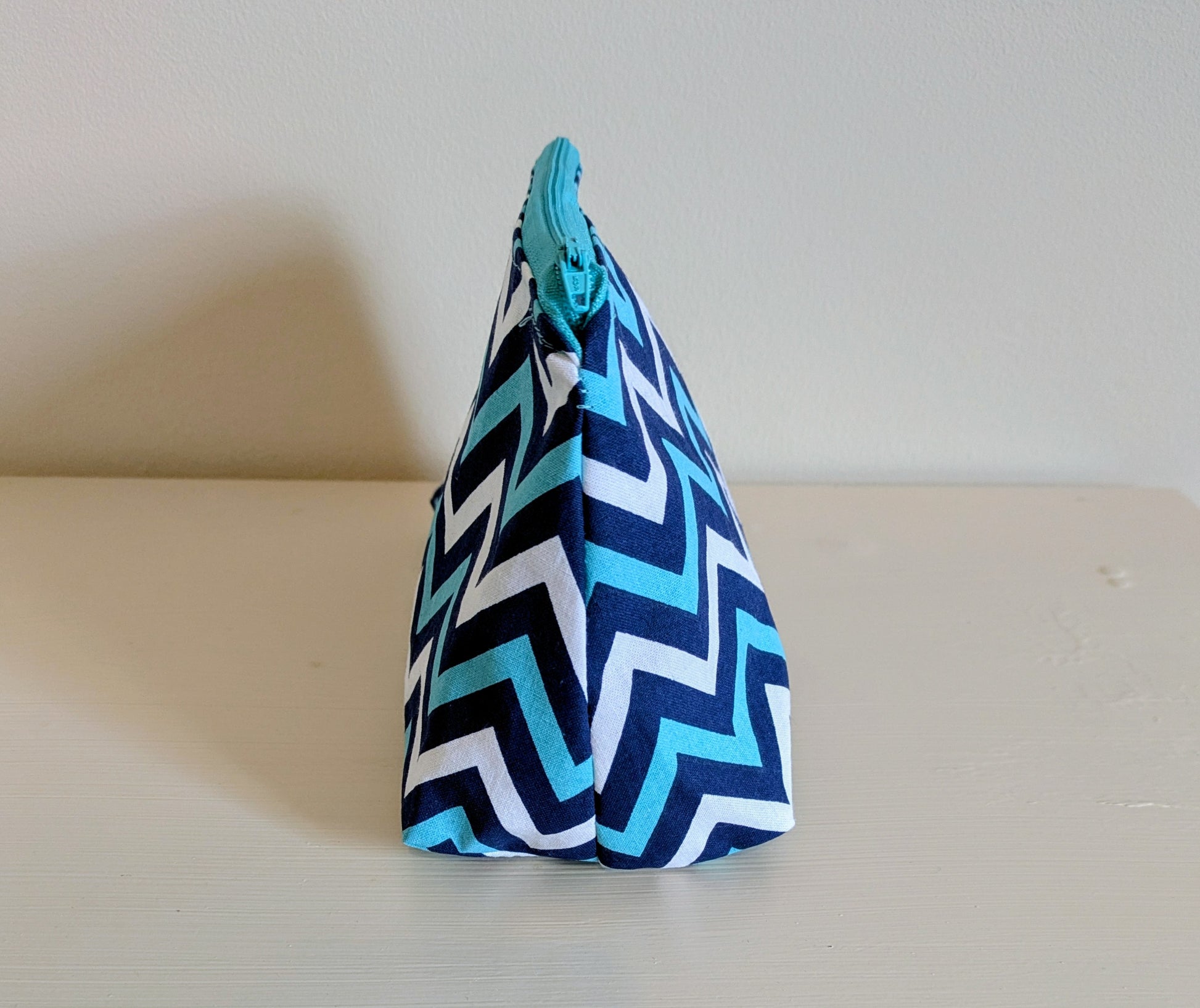 Blue and white zigzag waterproof wash bag by Harrie's Crafts, with a compact design and durable fabric for travel use.
