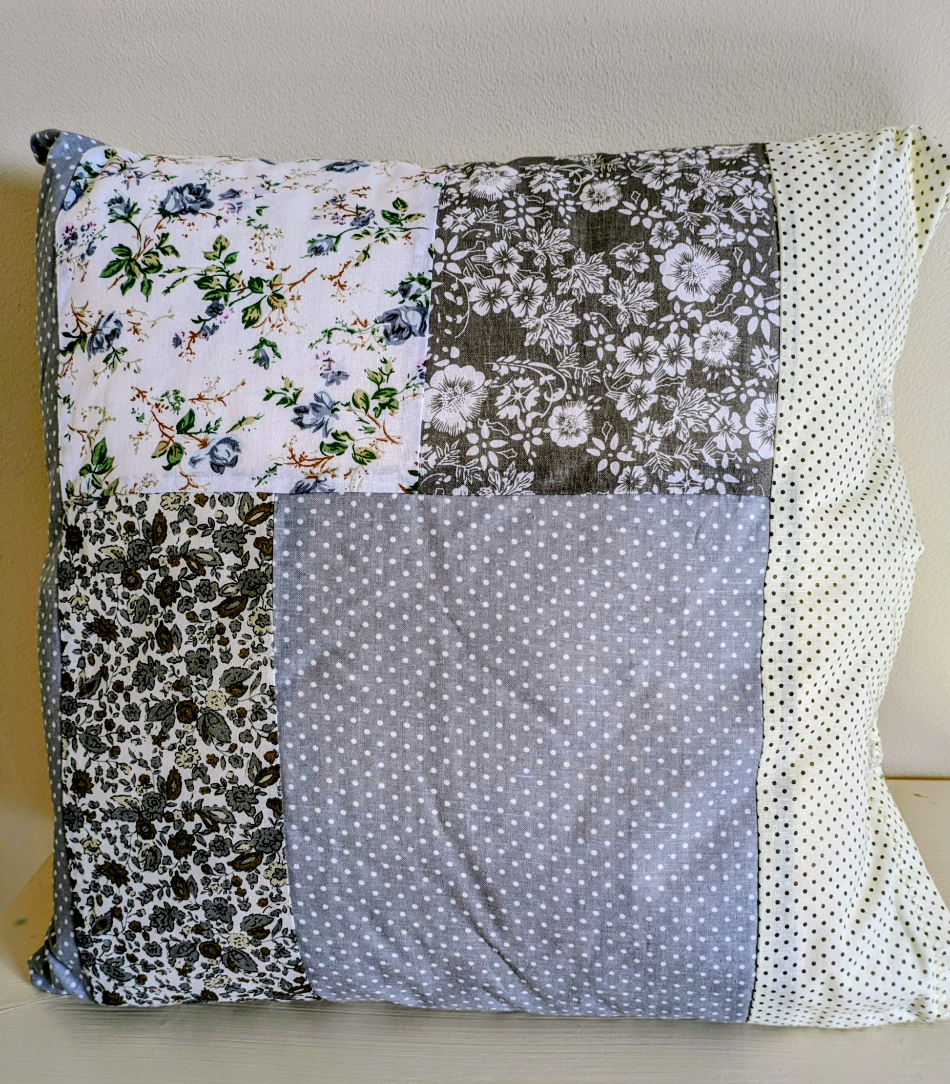Grey patchwork cushion by Harrie's Crafts featuring a cozy, stitched fabric design perfect for home decor.
