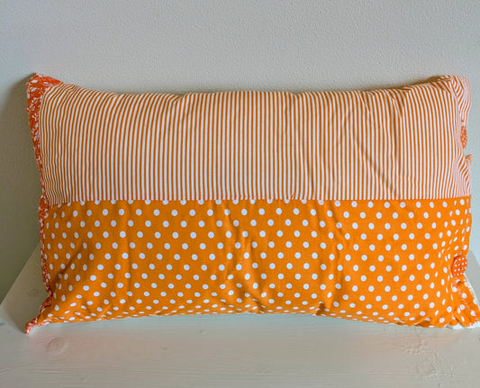 Orange patchwork cushion by Harrie's Crafts featuring vibrant mixed fabric squares and a soft, plush texture.