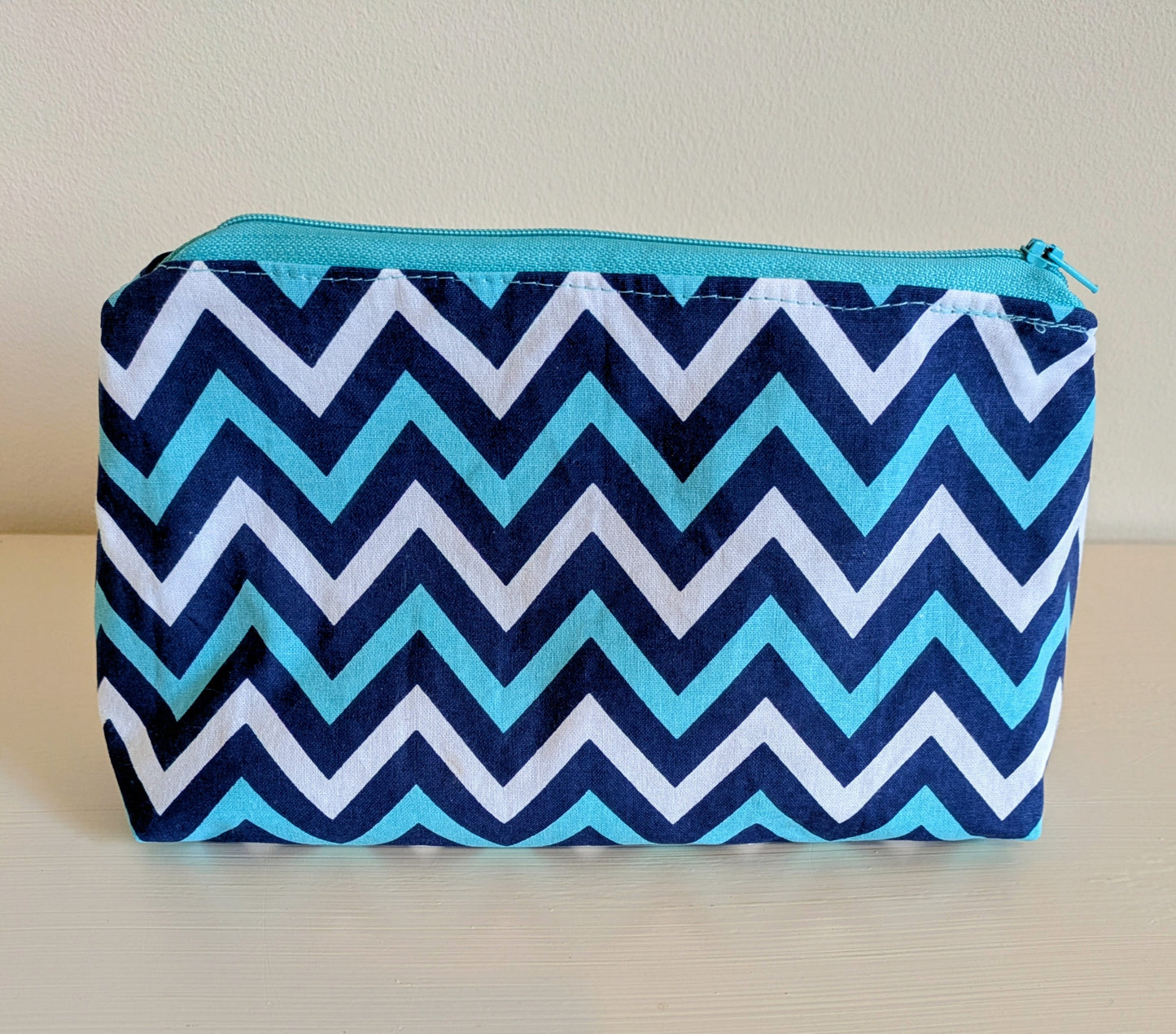 Blue and white zig zag waterproof wash bag by Harrie's Crafts, showing a close-up of the fabric pattern and zipper detail.
