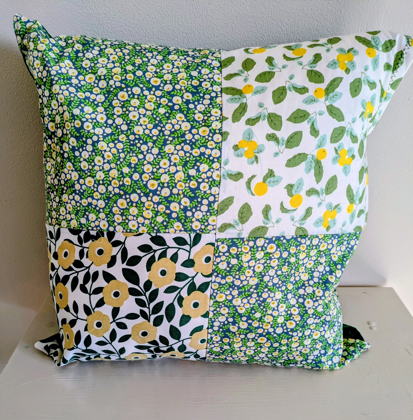 Colorful flower patchwork cushion by Harrie's Crafts featuring vibrant floral fabric and cozy design.