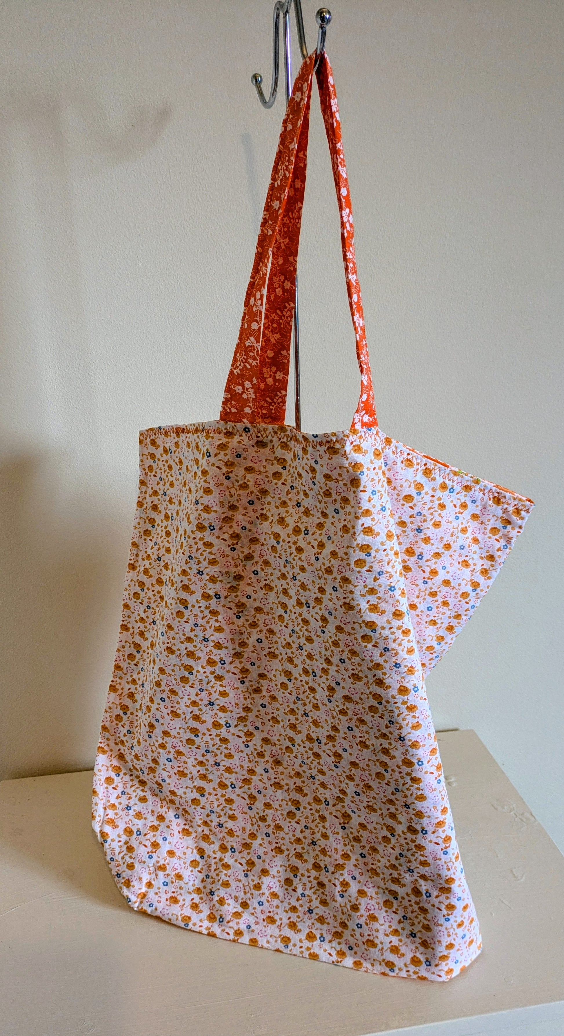 Orange tote bag by Harrie's Crafts with sturdy handles and spacious interior, perfect for casual or everyday use.