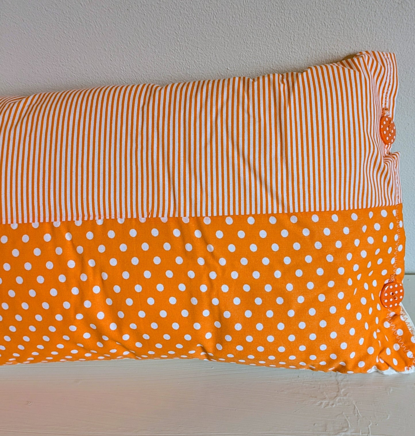 Orange patchwork cushion by Harrie's Crafts with vibrant fabric squares and cozy design, perfect for home decor.