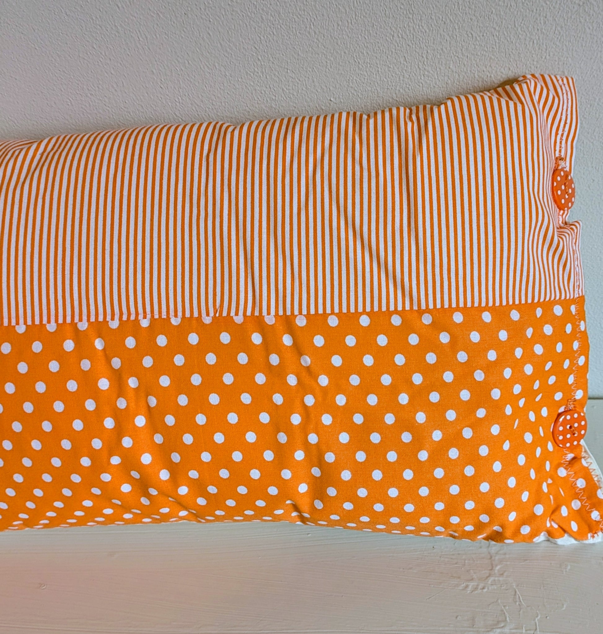 Orange patchwork cushion by Harrie's Crafts with vibrant fabric squares and cozy design, perfect for home decor.