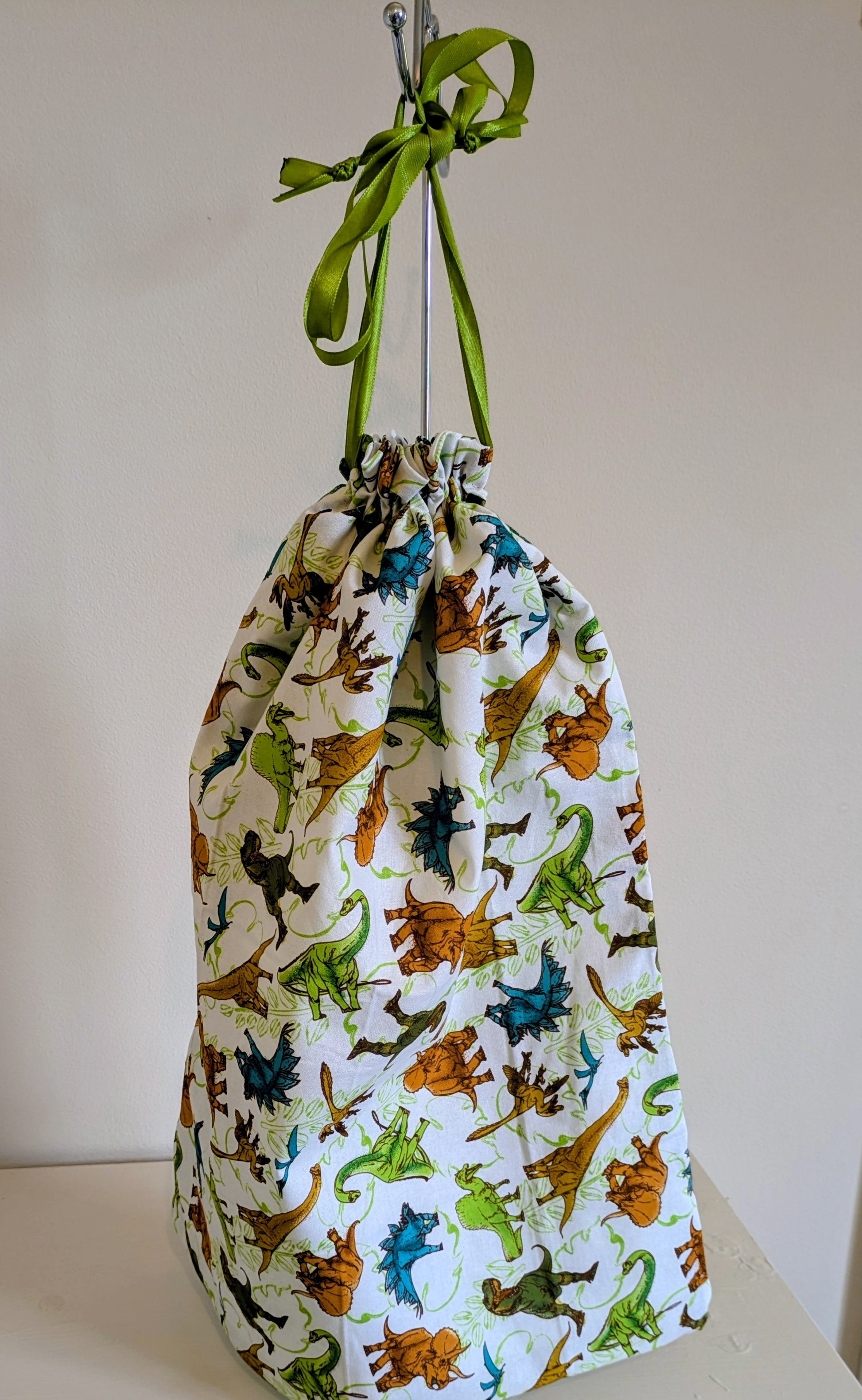 Dinosaur waterproof drawstring bag by Harrie's Crafts featuring colorful dinosaur illustrations on durable fabric.
