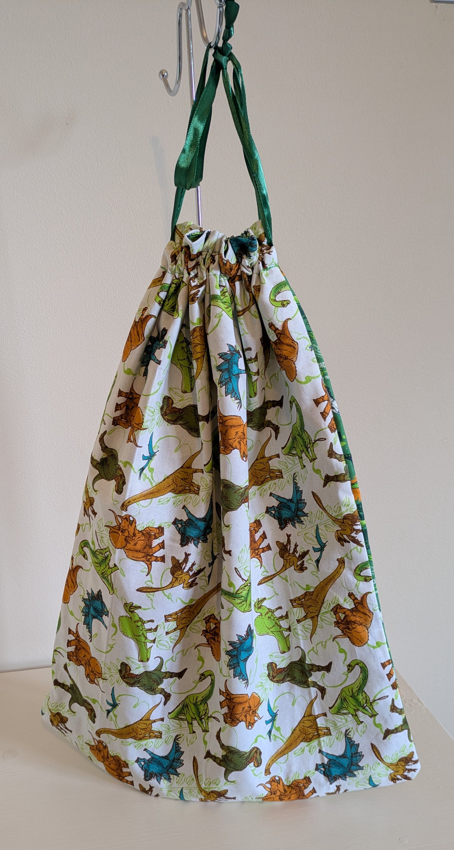 Harrie's Crafts dinosaur drawing bag with colorful dinosaur illustrations on durable fabric, ideal for kids' art supplies.